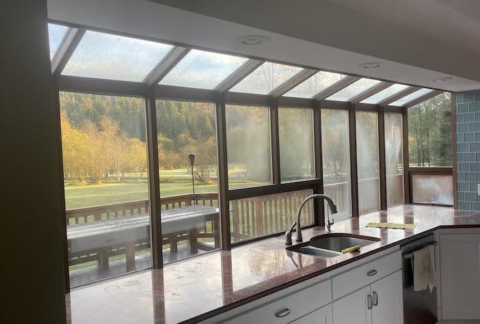 Kitchen skywall before replacement — dated bronze frames with foggy, failed-seal glass